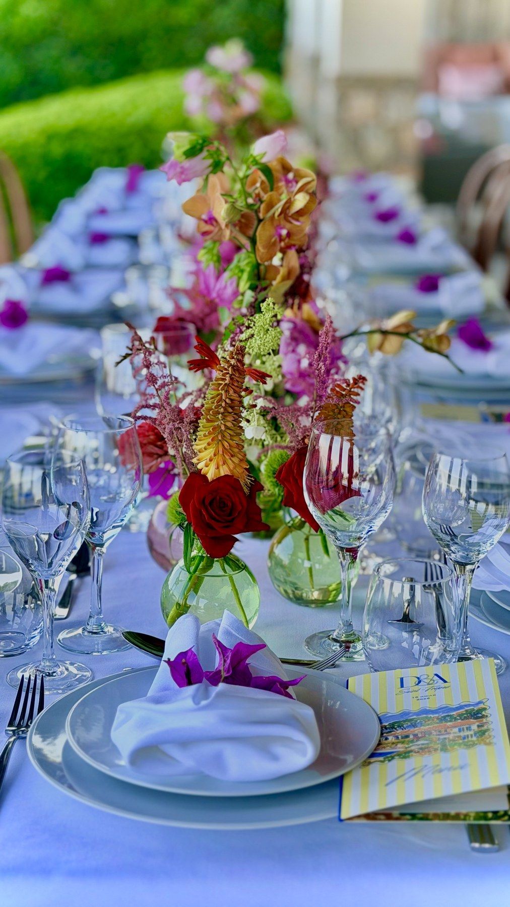 Fuchsia floral centrepiece and printed menus on lavender linen.