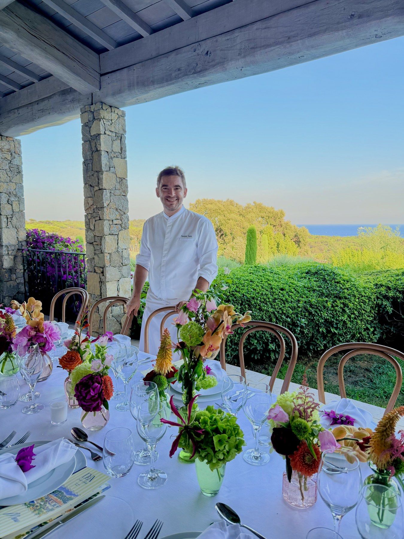 Chef François Savin at the head of a flowered banquet table.