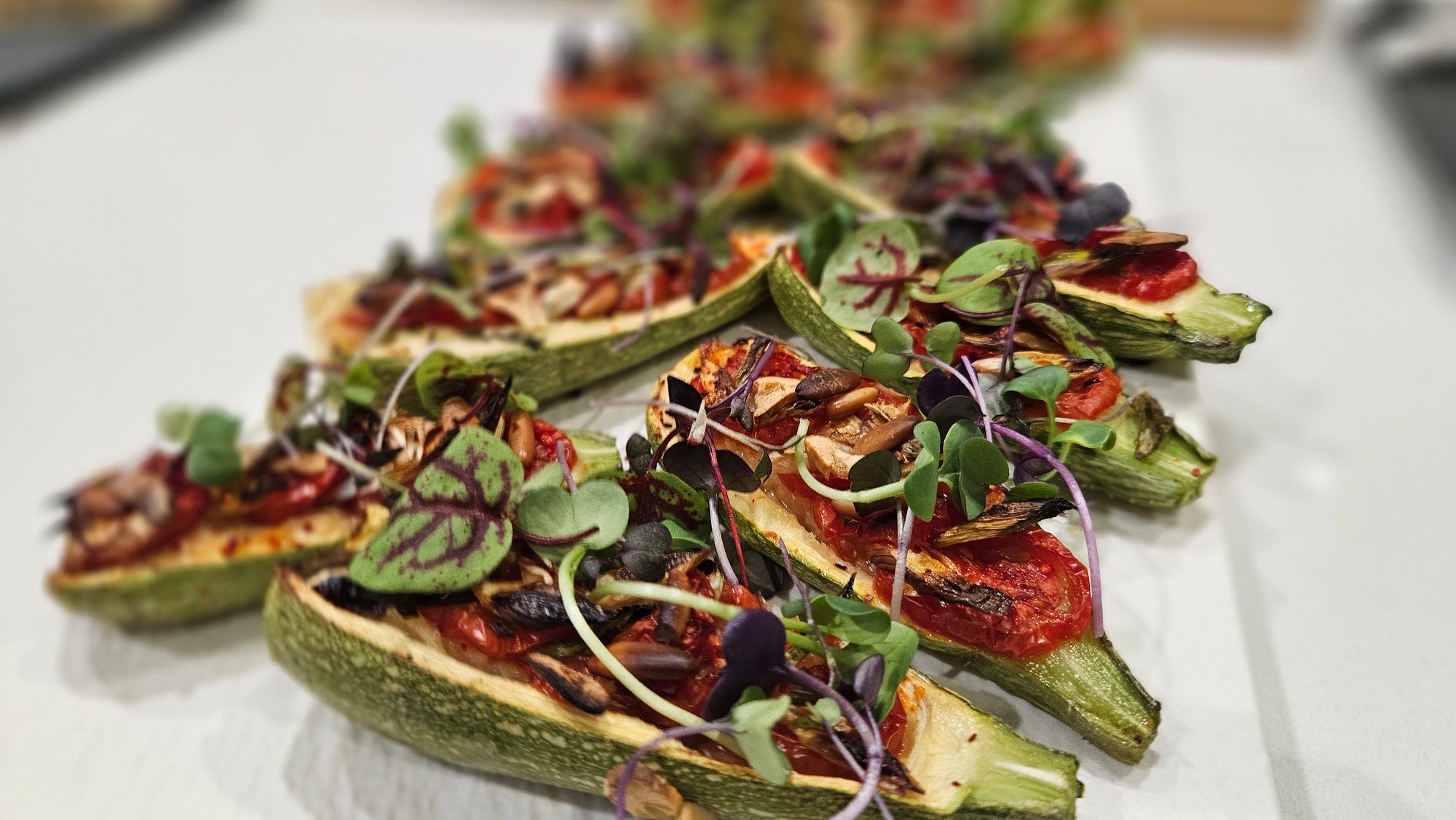 Stuffed baby courgettes with tomatoes and micro greens.