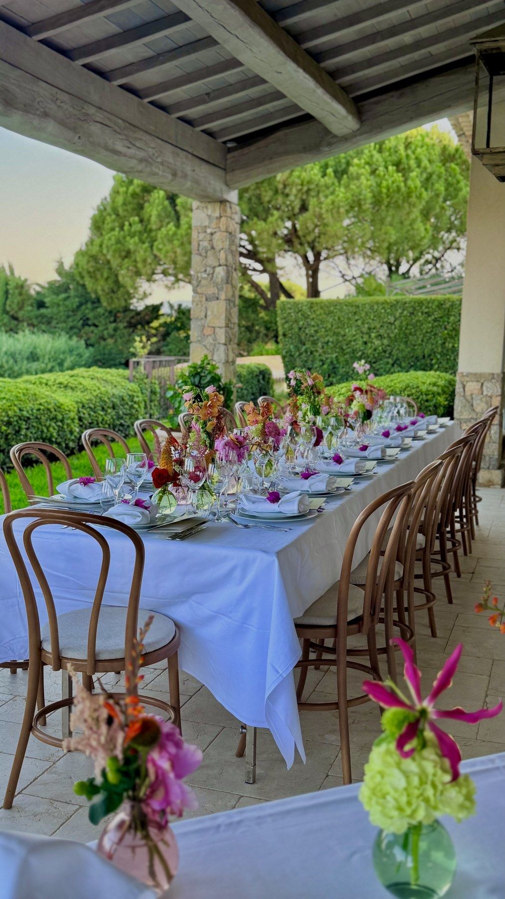 Long flowered table under the pergola, garden and sea beyond.