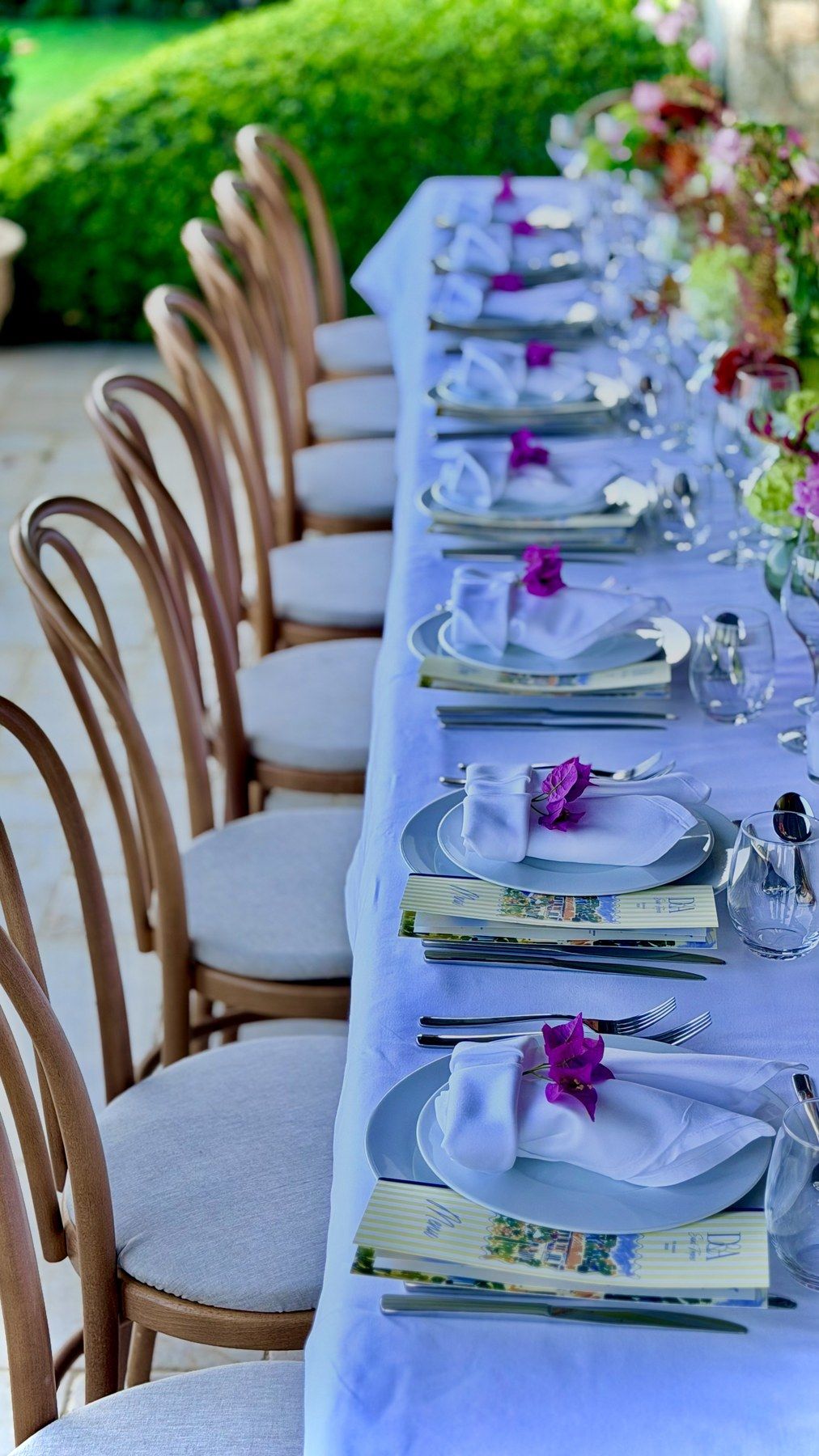 Bentwood chairs lined along a lavender-linen banquet table.