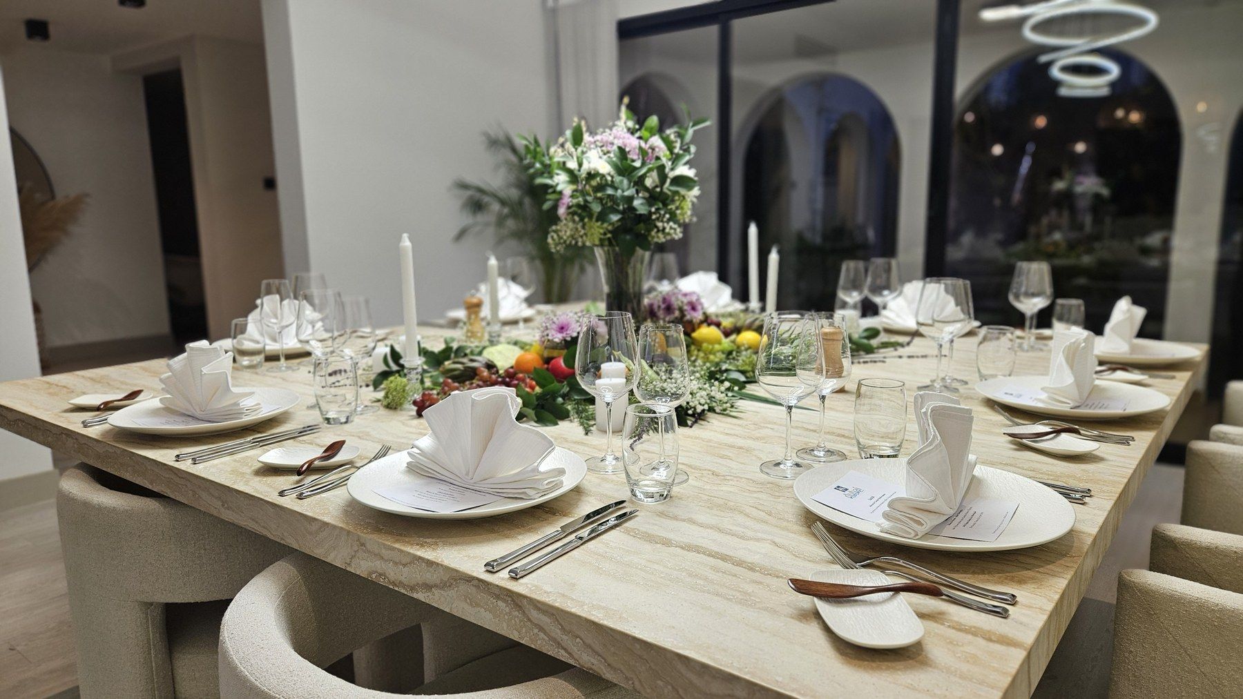 Marble dining room, table dressed in white linen and flowers.