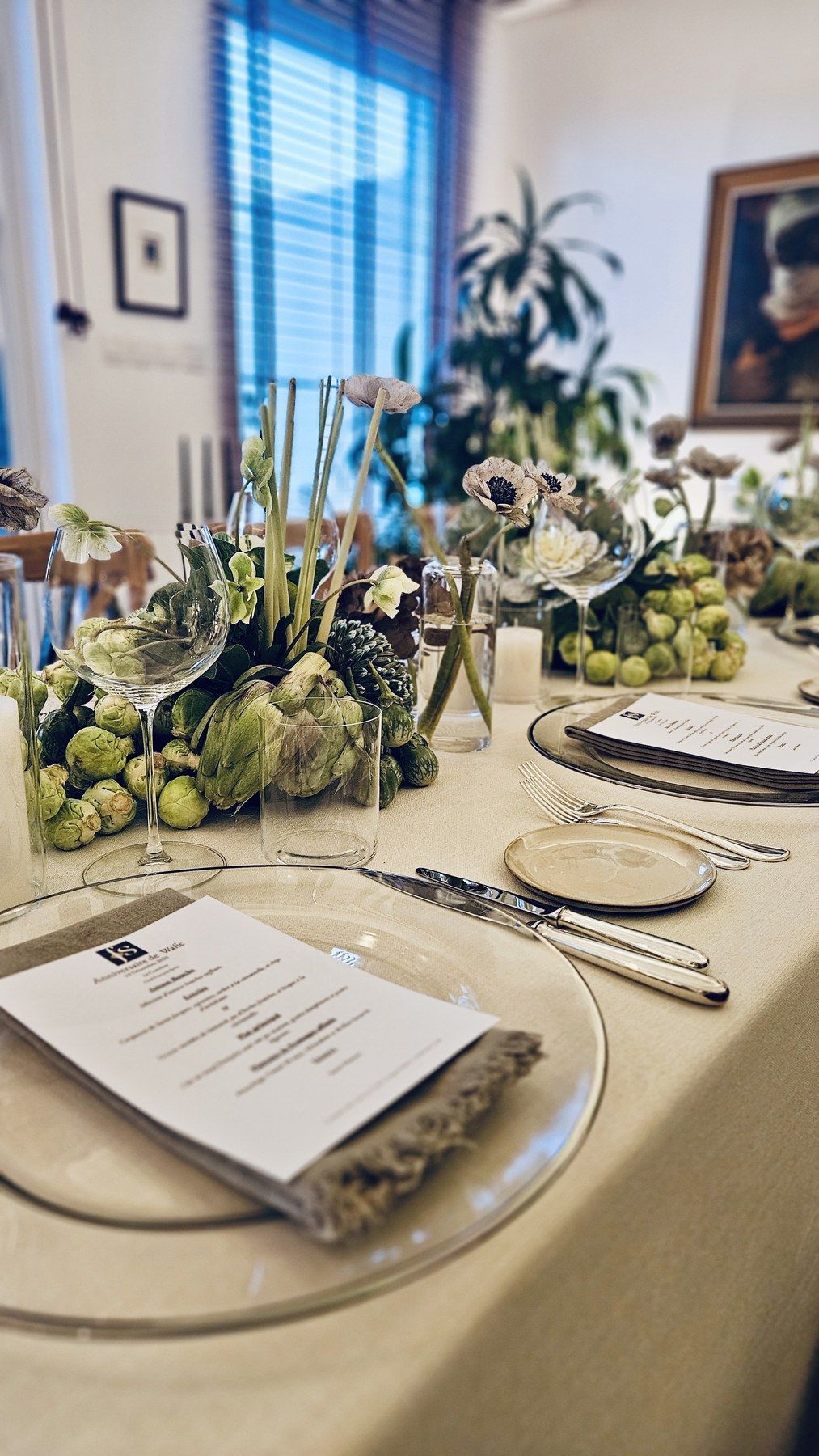 Place setting with printed menu and artichoke-and-grape centrepieces.