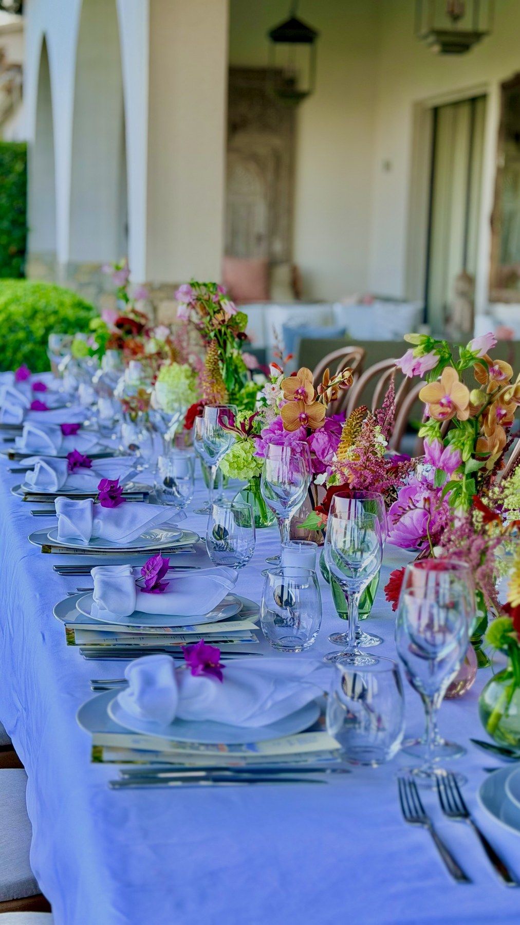 Long garden table in lavender linen with vivid floral runners.