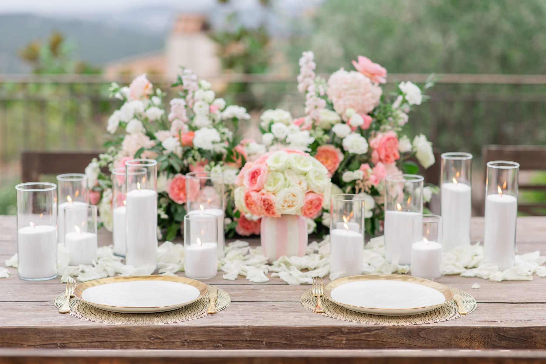 Wedding table with pink peonies, roses and candles.