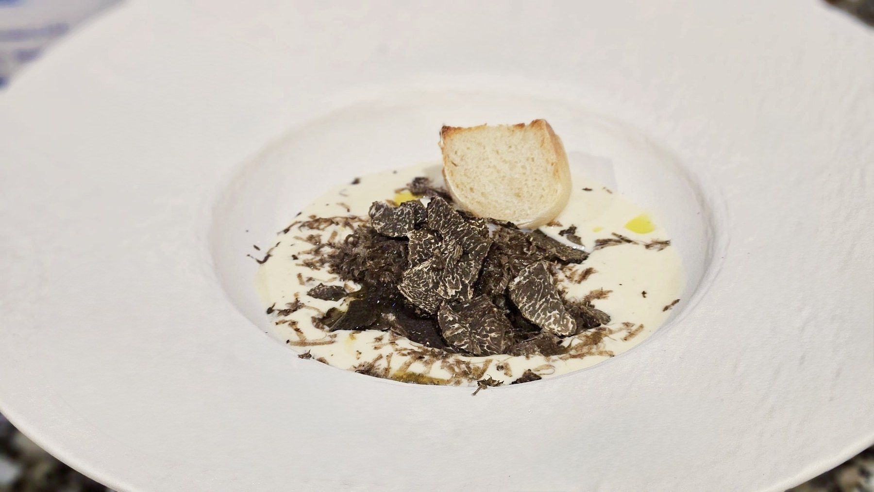 Shaved black truffle over a creamy base, finished with a bread crisp.