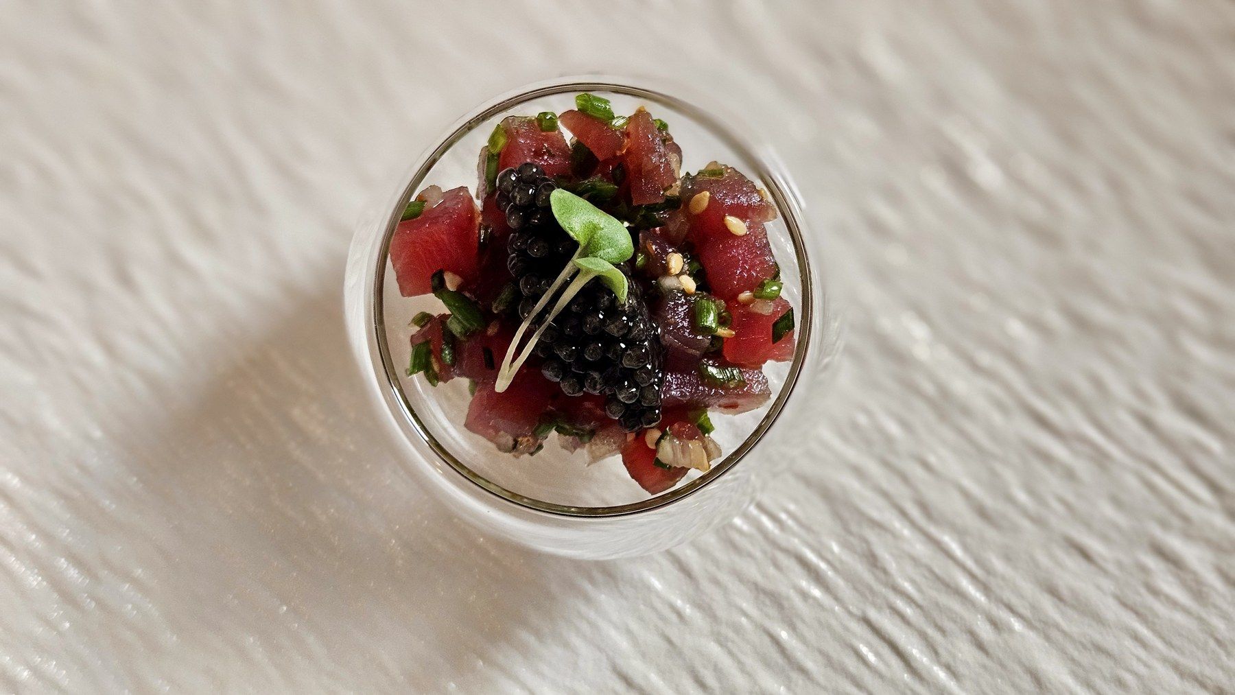 Tuna tartare verrine finished with micro herbs.